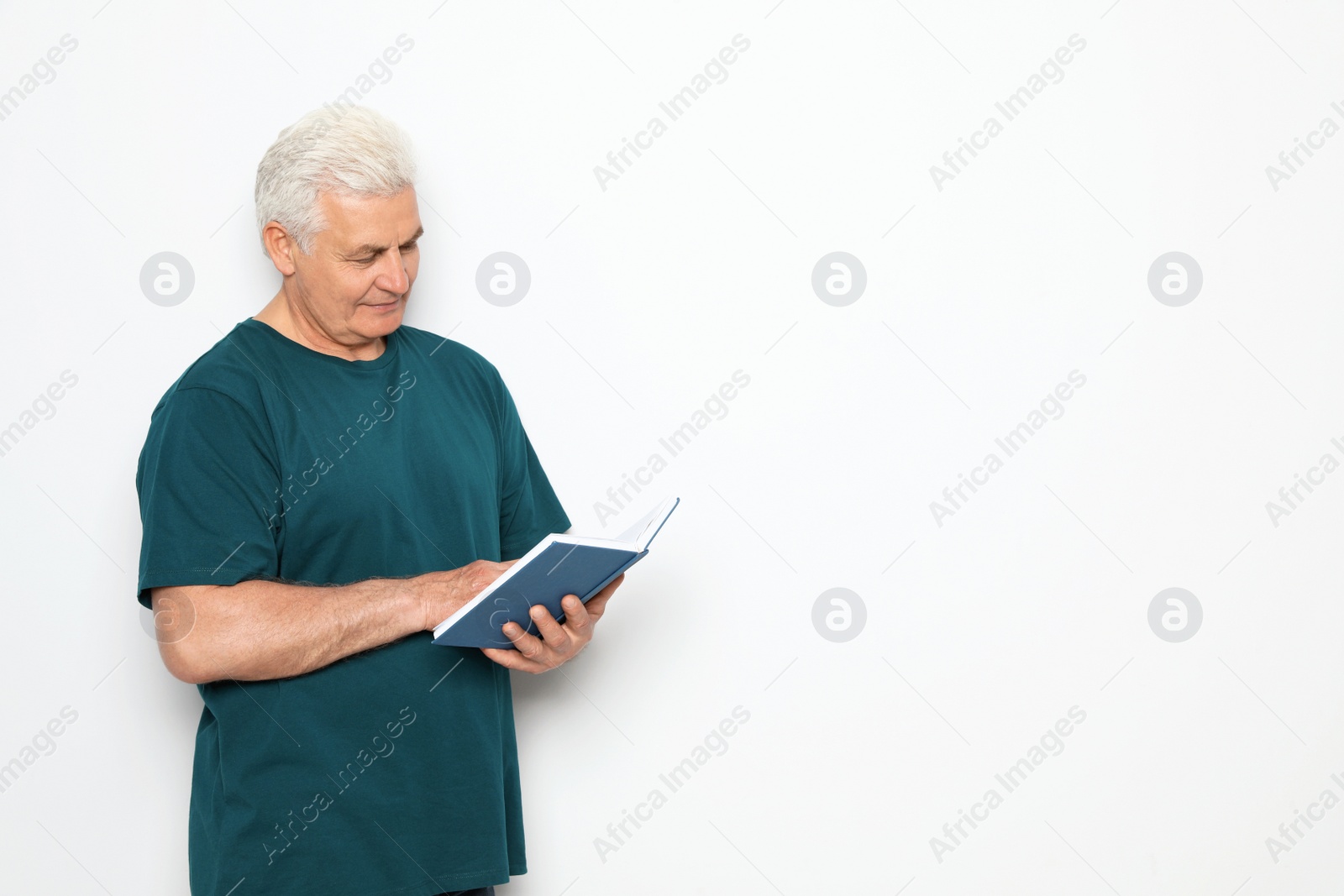 Photo of Senior man reading book on white background, space for text