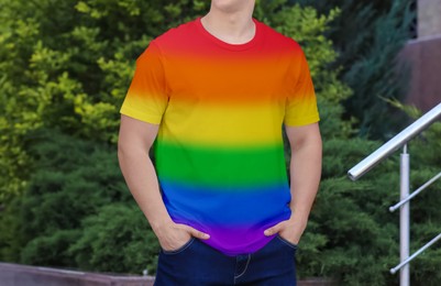 Image of Young man wearing rainbow t-shirt outdoors. LGBT concept