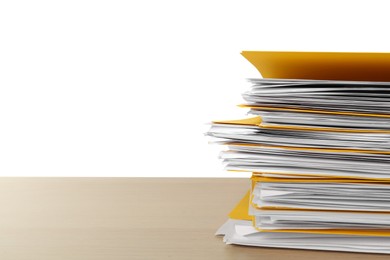 Stack of yellow files with documents on wooden table against white background. Space for text