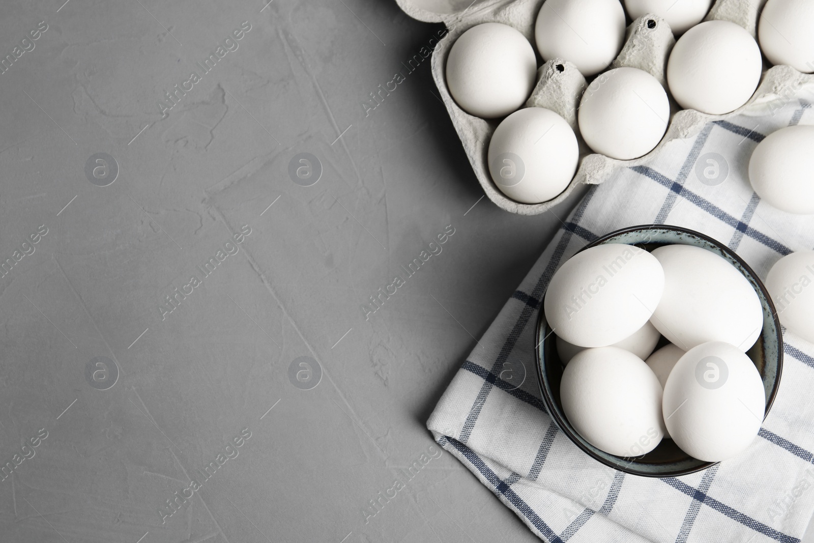 Photo of Flat lay composition with raw chicken eggs on grey table. Space for text