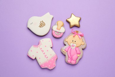 Photo of Set of baby shower cookies on lilac background, flat lay