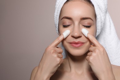 Woman using silkworm cocoons in skin care routine on light grey background. Space for text