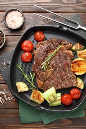 Photo of Delicious grilled beef steak and vegetables served on wooden table, flat lay