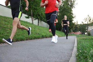 Group of people running outdoors, closeup view