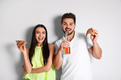 Photo of Happy couple with pizza and beer on white background