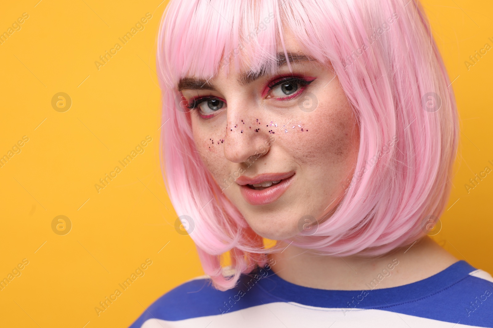 Photo of Beautiful woman with bright makeup and glitter freckles on yellow background. Space for text