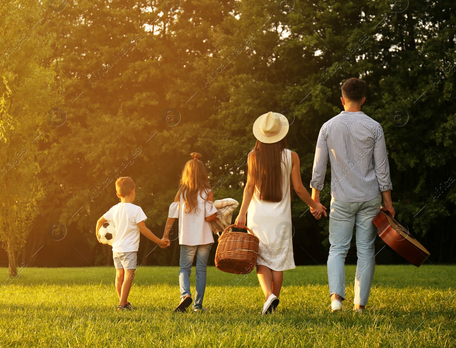 Photo of Happy family with picnic basket in park