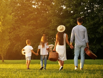 Happy family with picnic basket in park