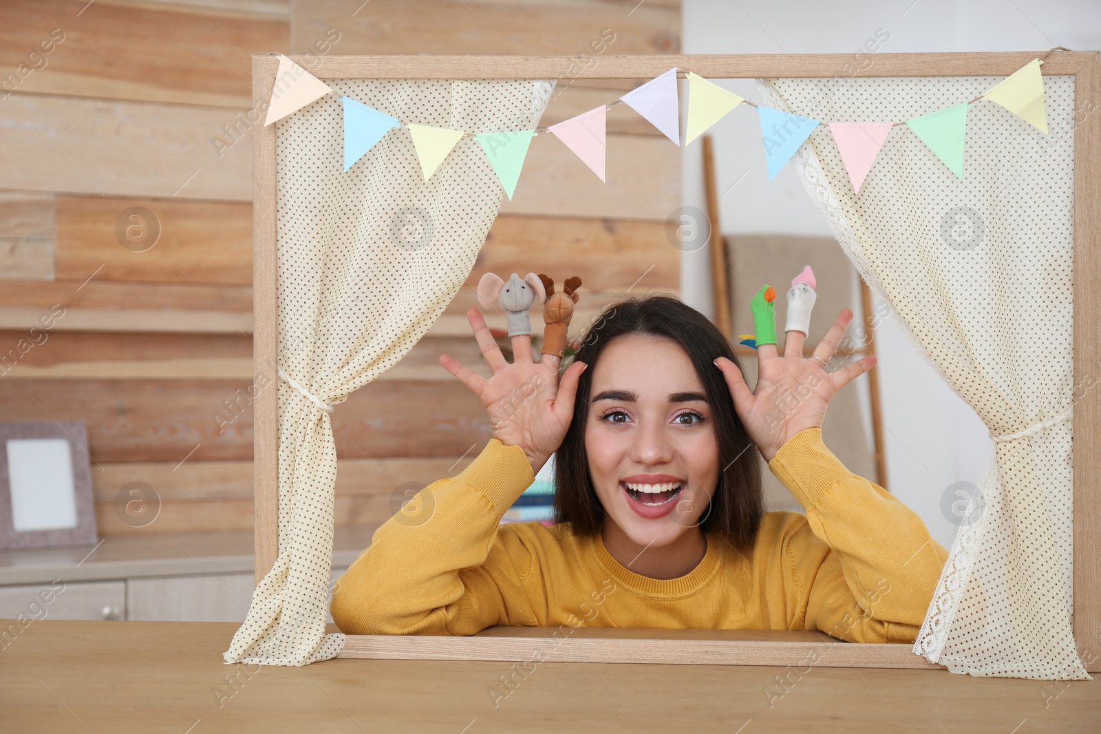 Photo of Young woman performing puppet show at home