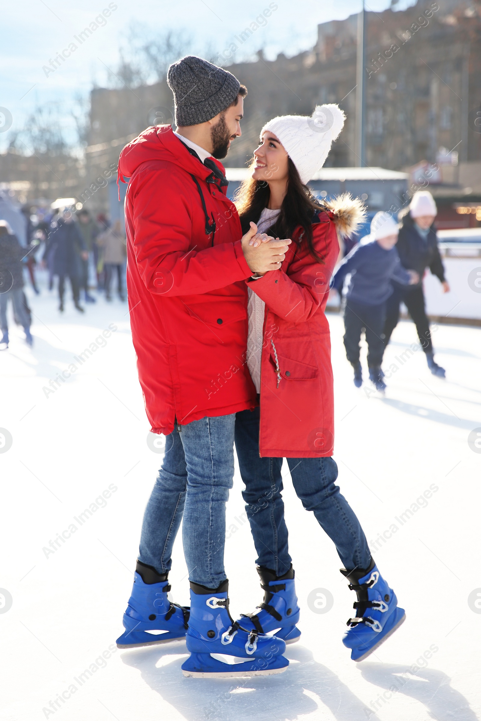 Image of Lovely couple spending time together at outdoor ice skating rink