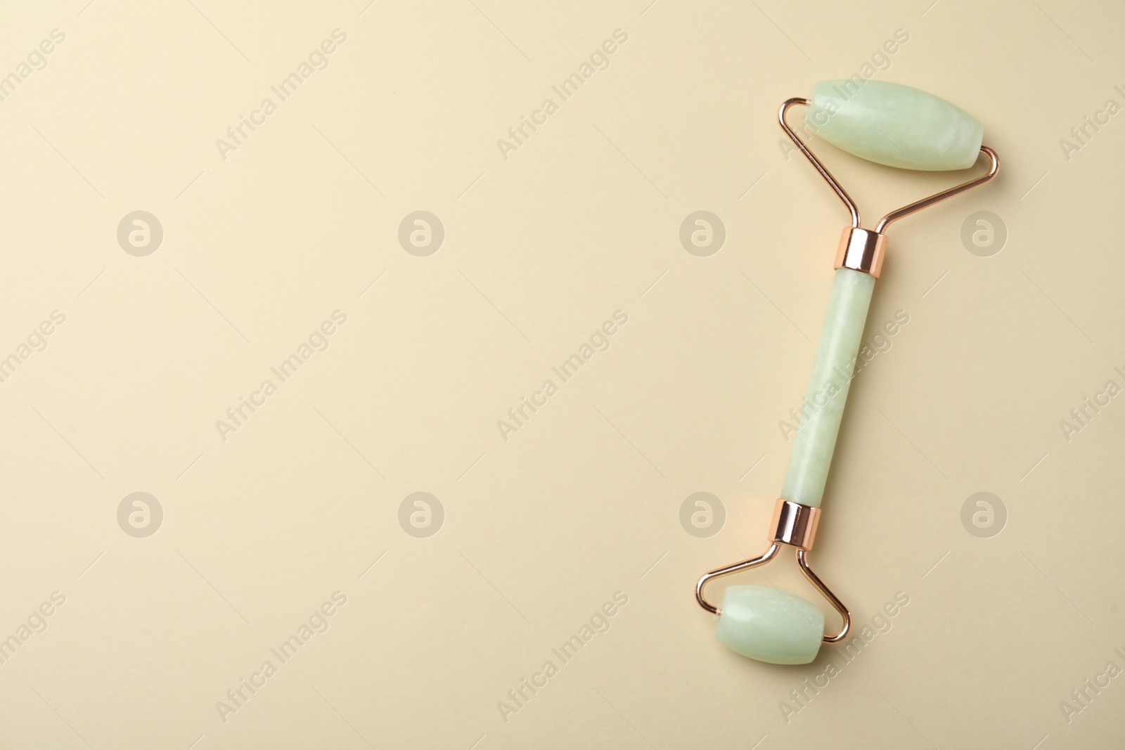 Photo of Natural face roller on beige background, top view. Space for text
