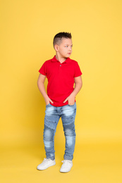 Photo of Full length portrait of cute little boy on yellow background