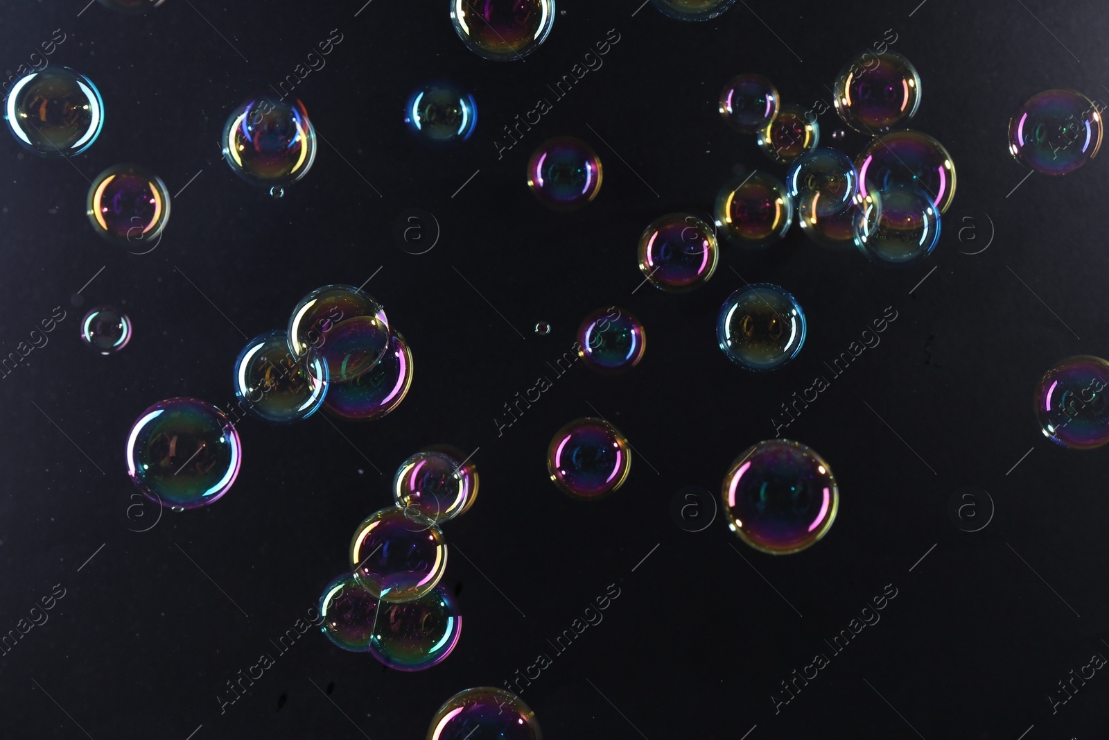 Photo of Beautiful transparent soap bubbles on dark background