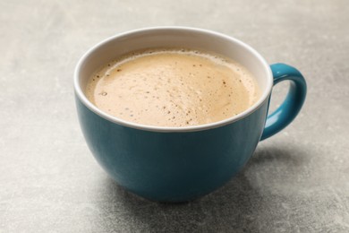 Photo of Cup of aromatic coffee on light grey table, closeup