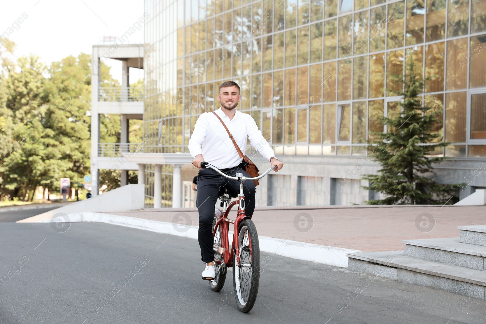 Photo of Attractive man riding bike on city street