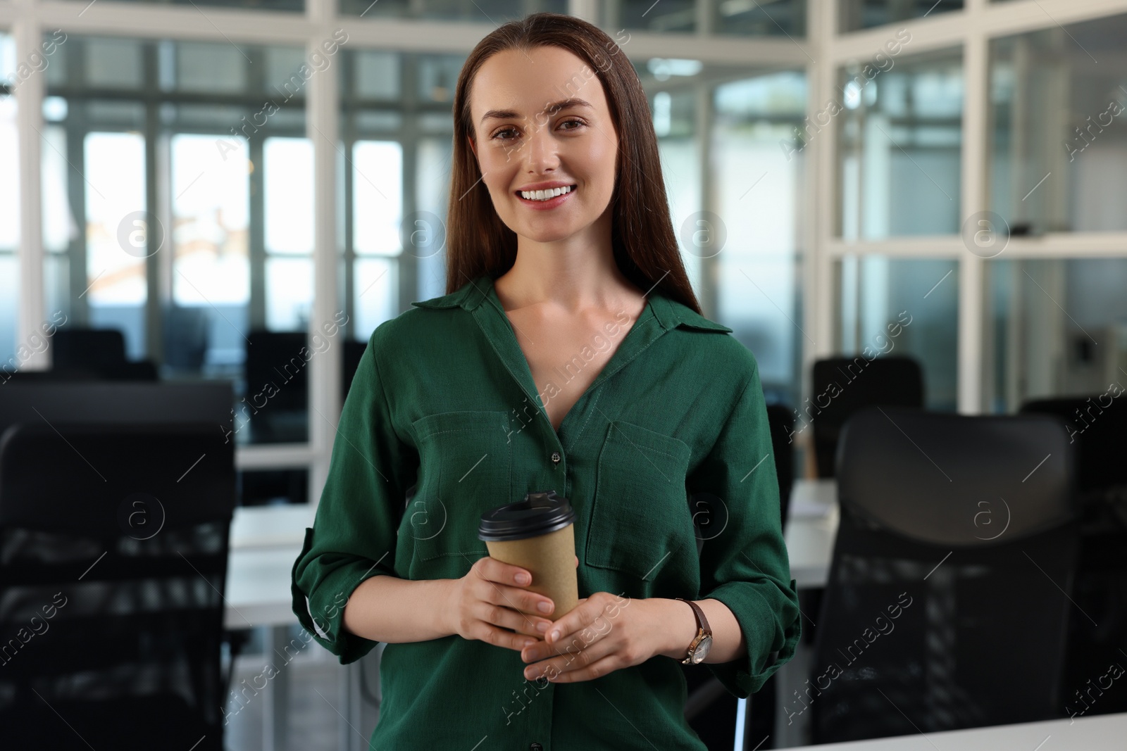 Photo of Happy woman with paper cup of drink in office