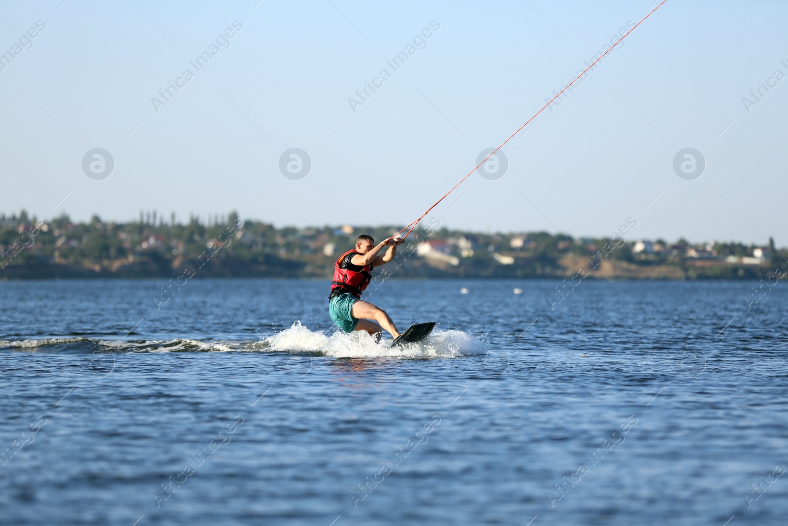 Photo of Man wakeboarding on river. Extreme water sport