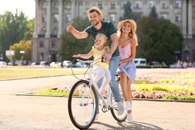 Happy family riding bicycle outdoors on summer day