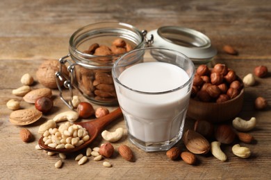 Photo of Vegan milk and different nuts on wooden table