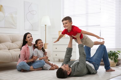 Photo of Happy family with children having fun in living room. Adoption concept