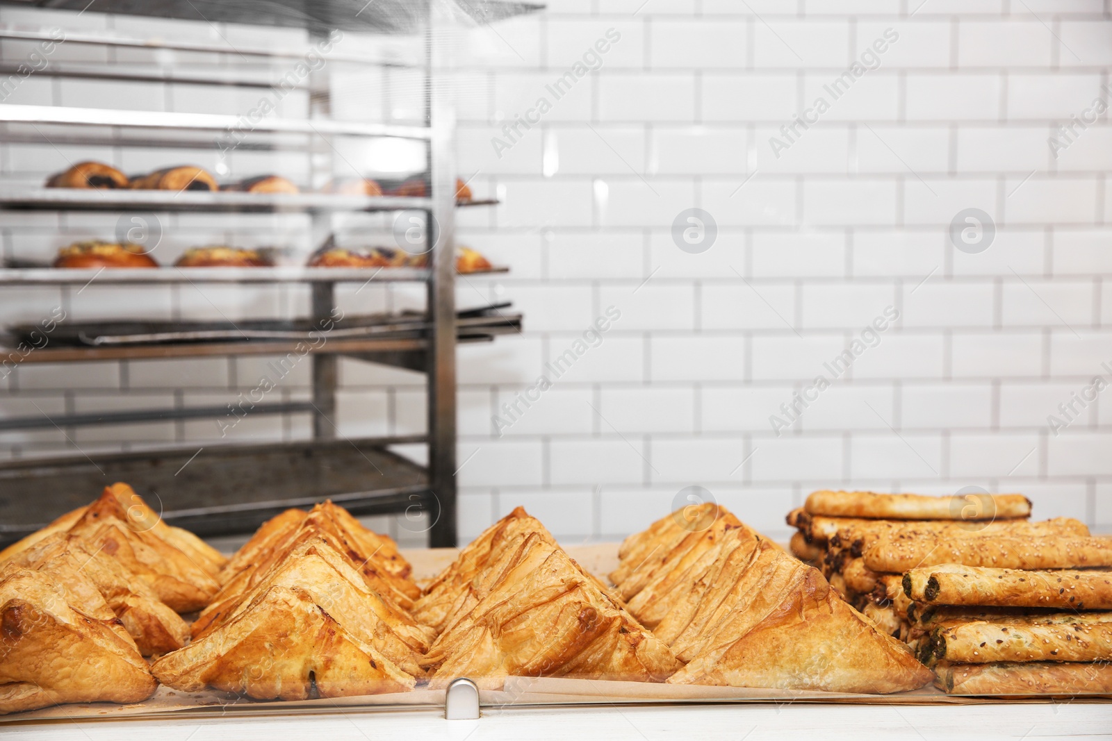 Photo of Fresh pastries on counter in bakery store. Space for text