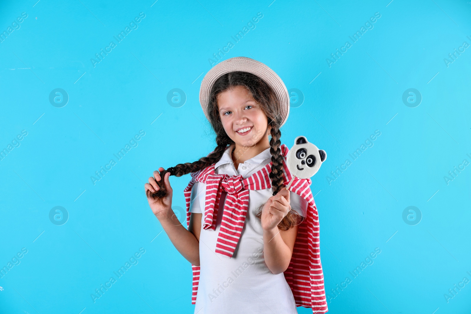 Photo of Little girl with candy on color background