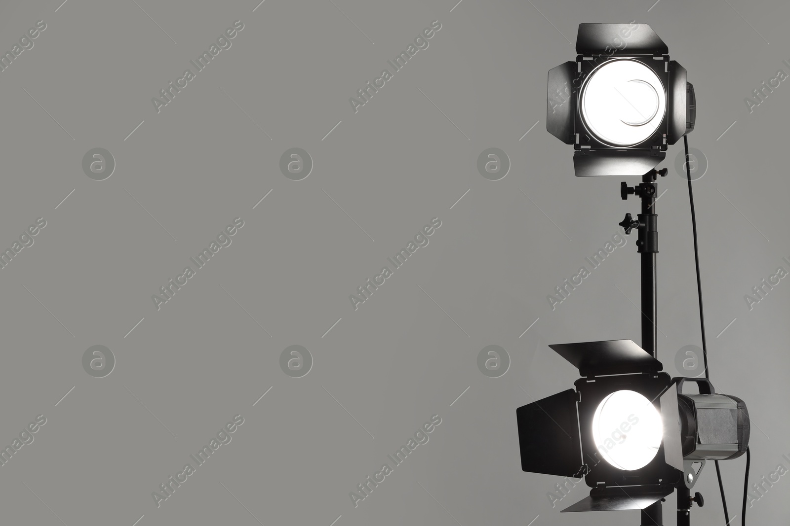 Photo of Grey photo background and professional lighting equipment in studio. Space for text