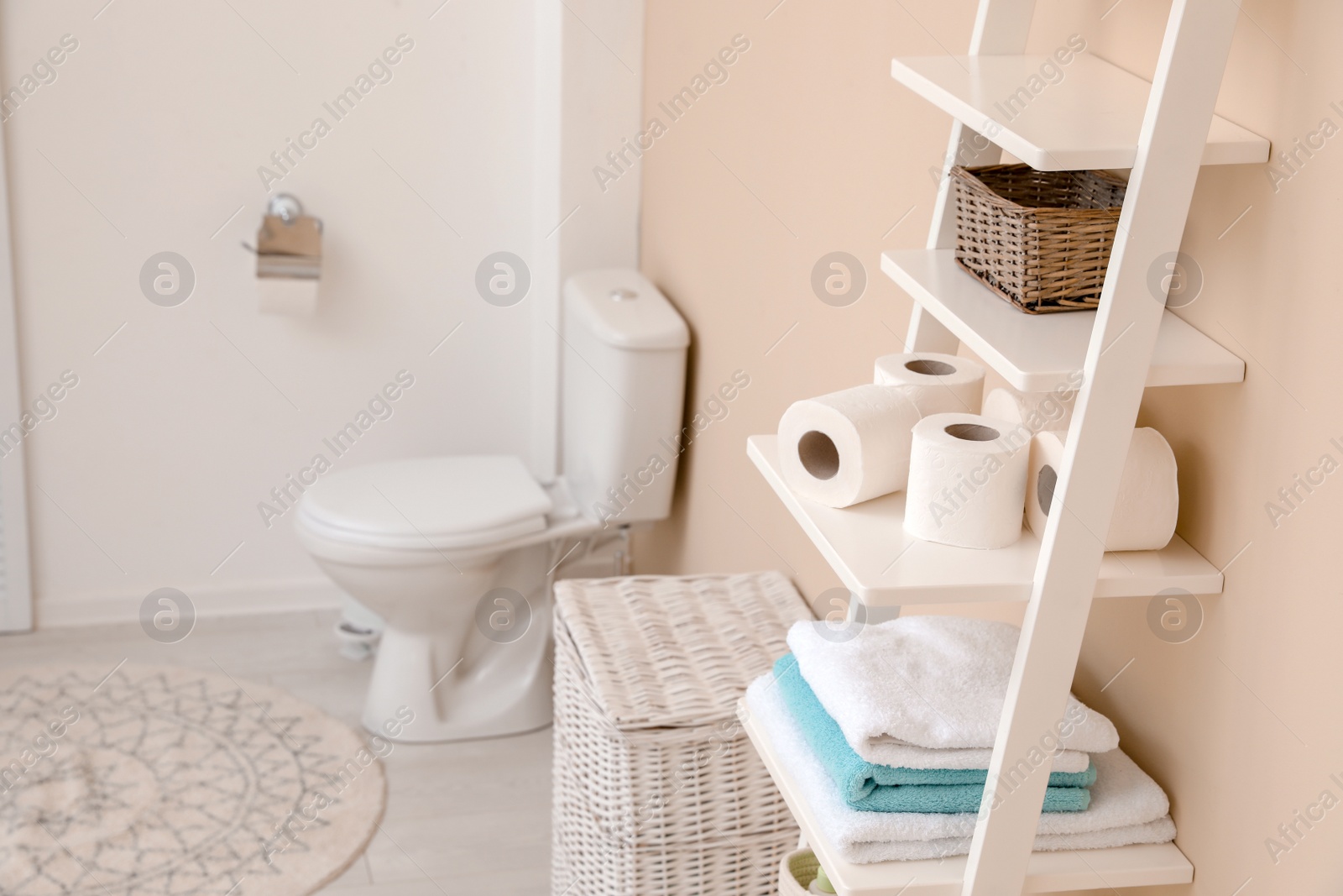 Photo of Toilet paper rolls on shelving unit in bathroom. Space for text