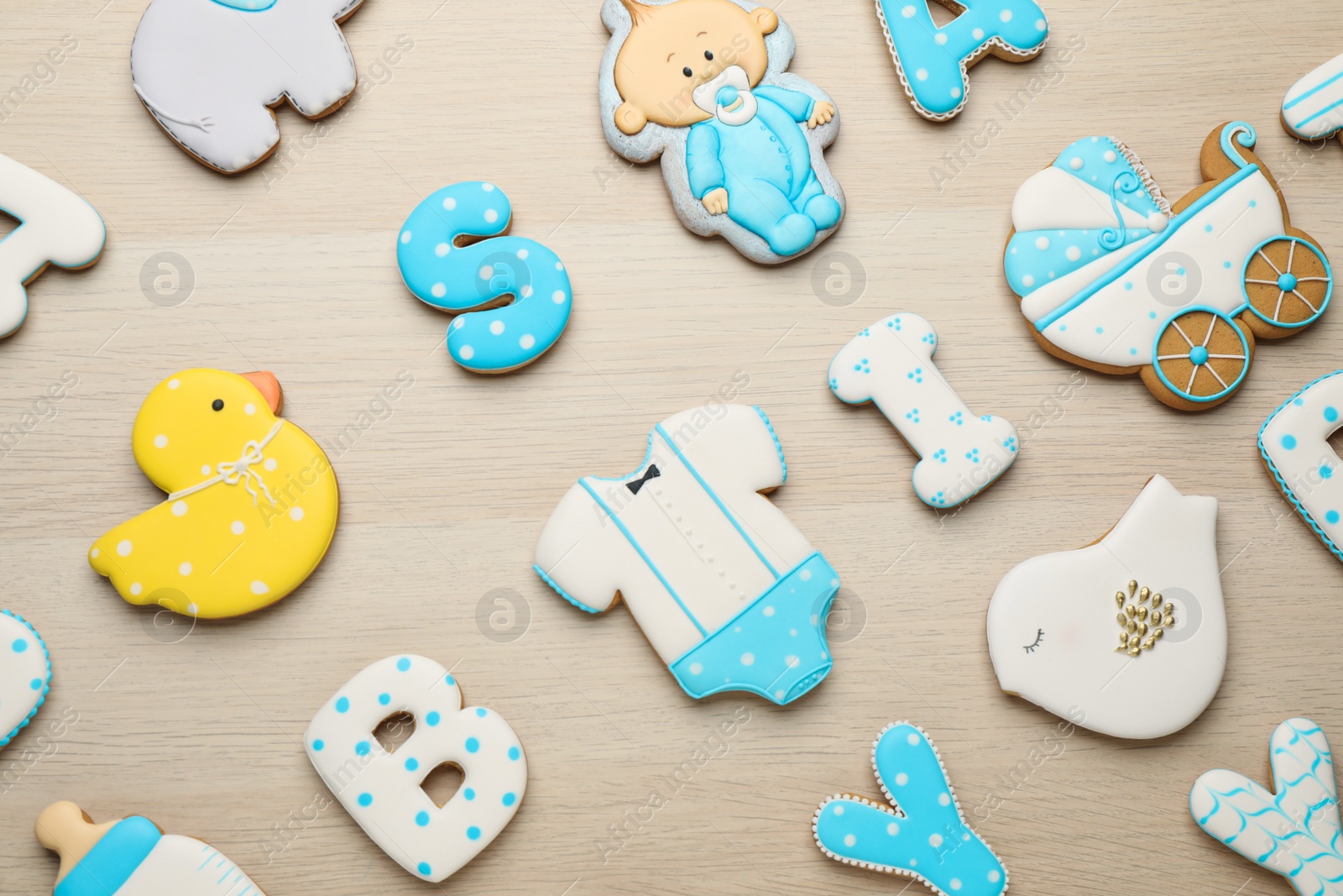 Photo of Set of baby shower cookies on wooden table, flat lay
