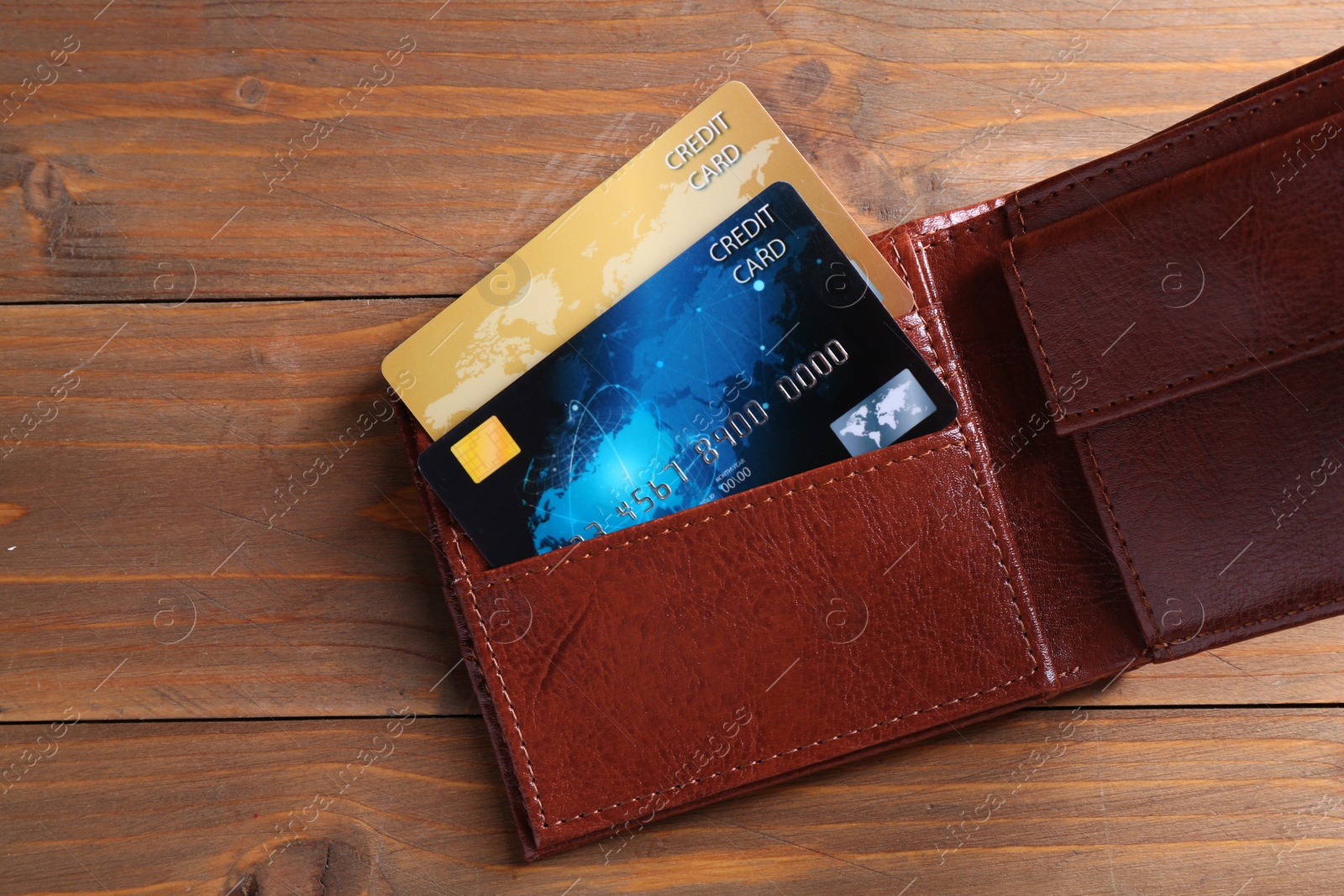 Photo of Credit cards in leather wallet on wooden table, top view