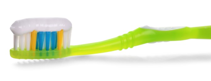 Photo of Green brush with toothpaste isolated on white
