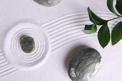 Photo of Zen concept. Stones, leaves and pattern on white sand, flat lay