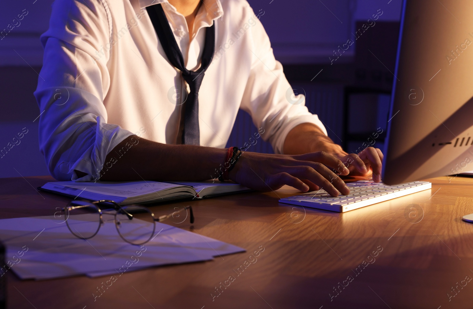 Photo of Man working late at desk in office, closeup