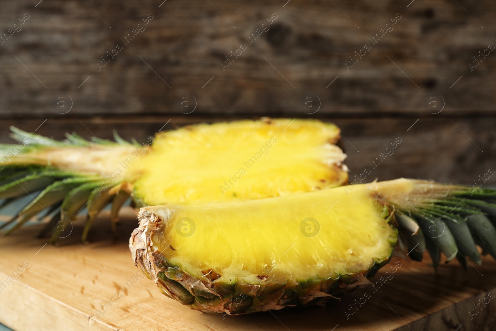 Photo of Cut fresh juicy pineapple on wooden board, closeup