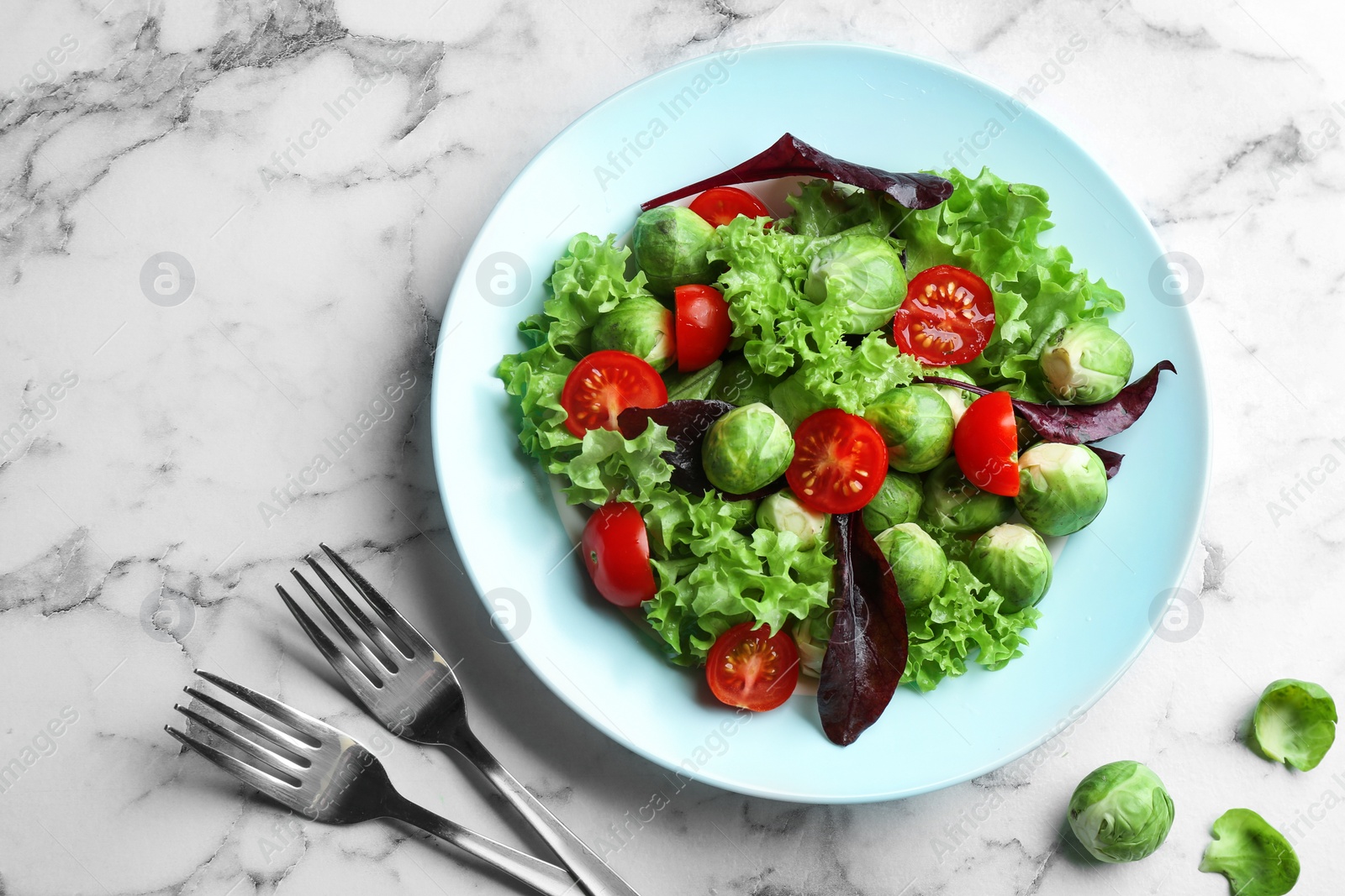 Photo of Tasty salad with Brussels sprouts served on white marble table, flat lay