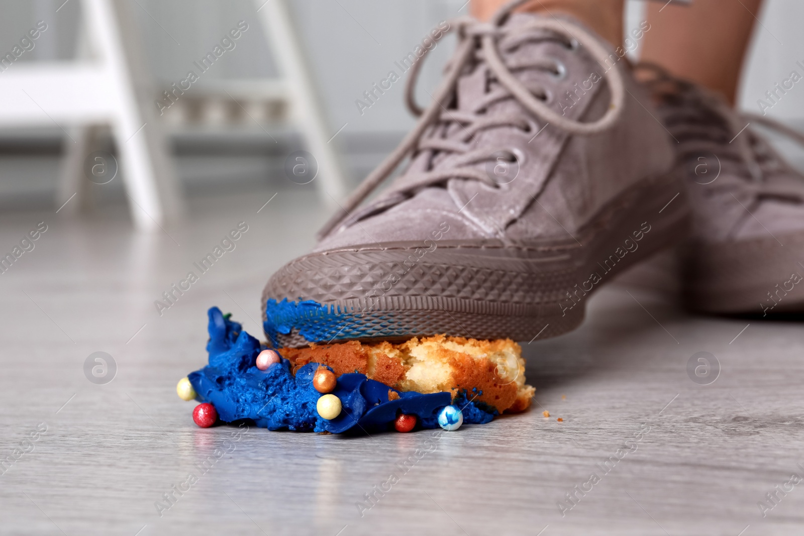 Photo of Woman stepping on dropped cupcake indoors, closeup. Troubles happen