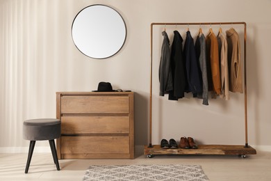 Photo of Modern dressing room interior with stylish clothes, shoes and mirror