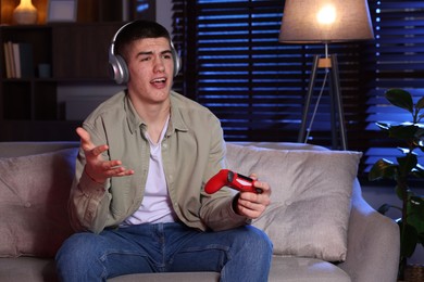 Man playing video games with controller at home
