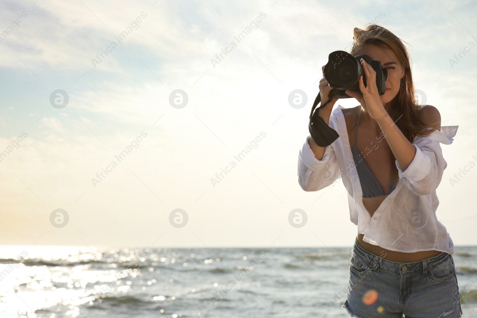 Photo of Photographer taking photo with professional camera near sea