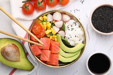 Delicious poke bowl with salmon, avocado and vegetables on white textured table, flat lay