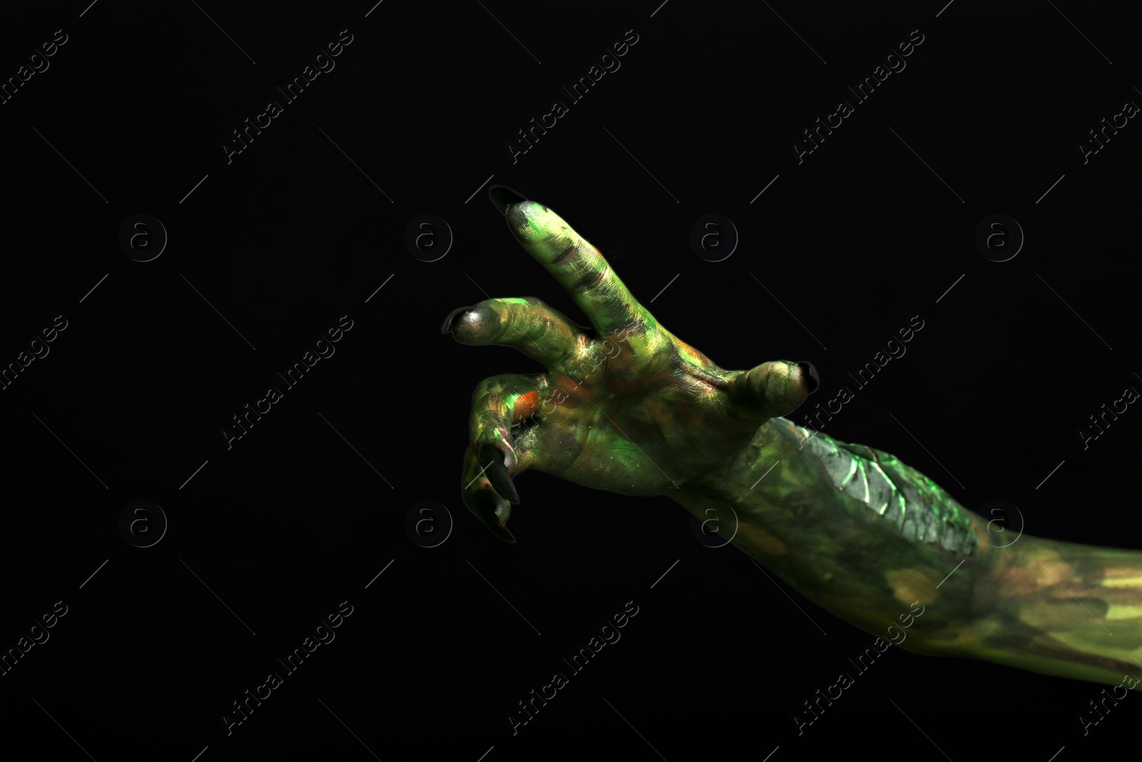 Photo of Scary monster on black background, closeup of hand. Halloween character