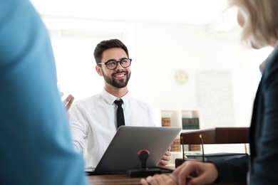 Male notary working with mature couple in office