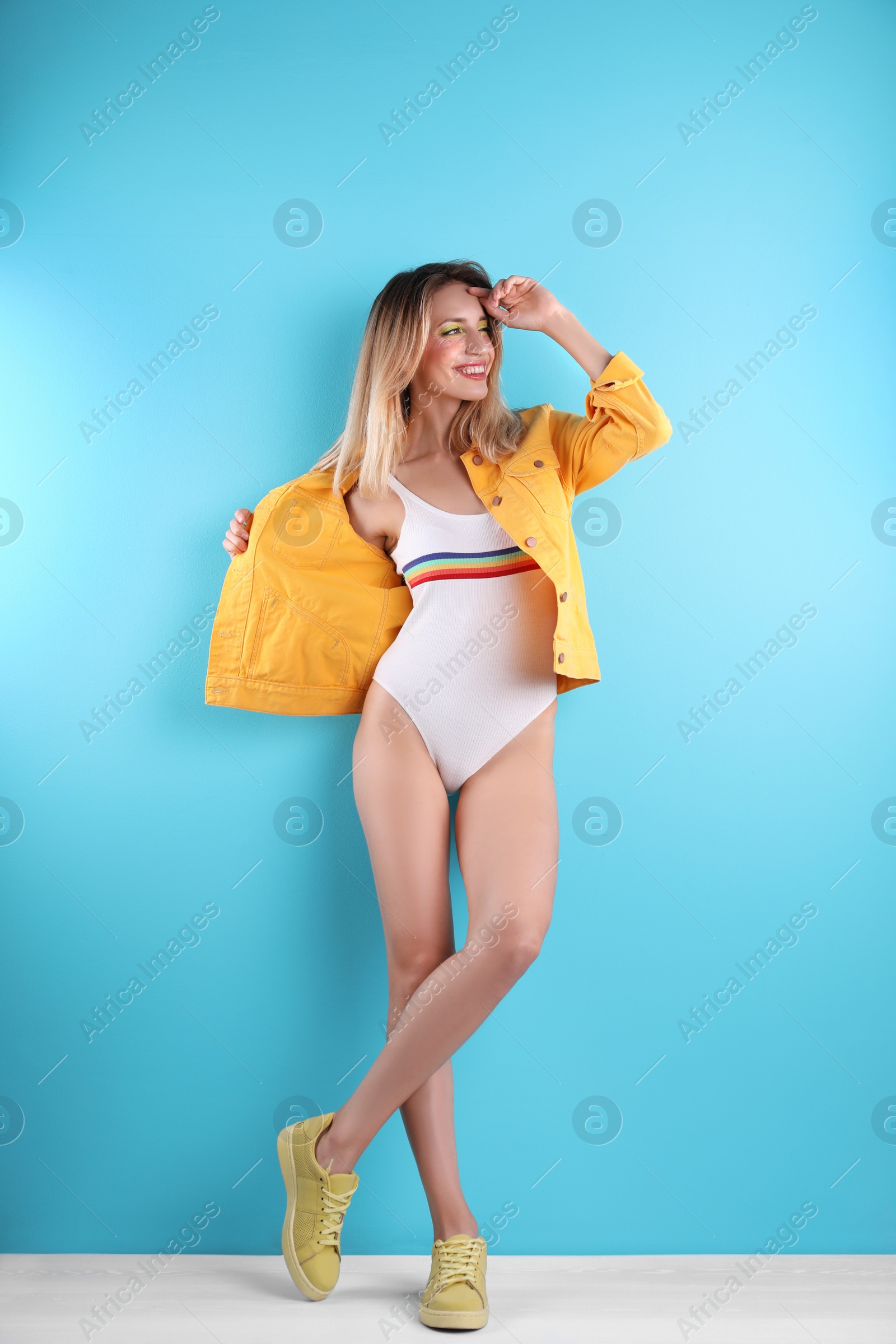 Photo of Beautiful young woman posing near color wall. Summer fashion