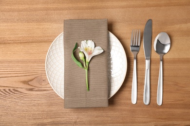 Photo of Flat lay composition with cutlery, plate and napkin on wooden background