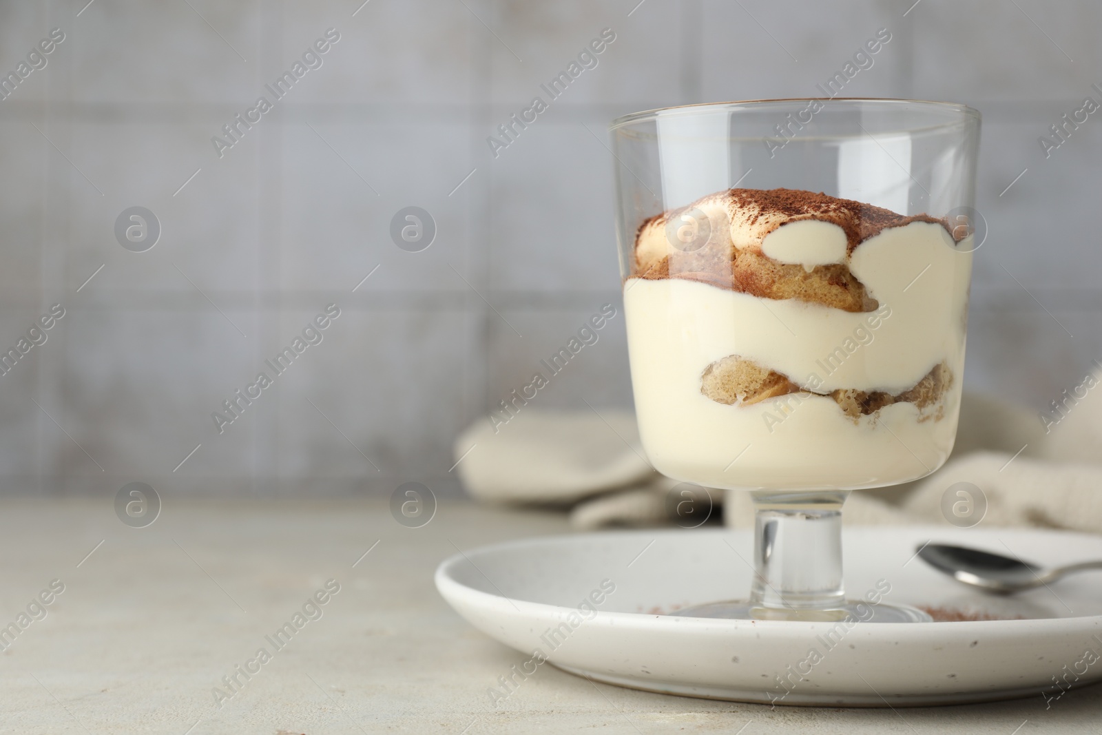 Photo of Delicious tiramisu in glass on light table. Space for text