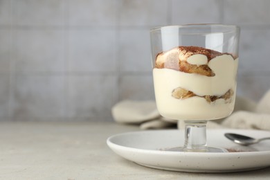 Photo of Delicious tiramisu in glass on light table. Space for text