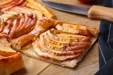 Piece of freshly baked apple pie on wooden table, closeup