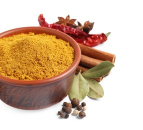 Curry powder in bowl and other spices isolated on white