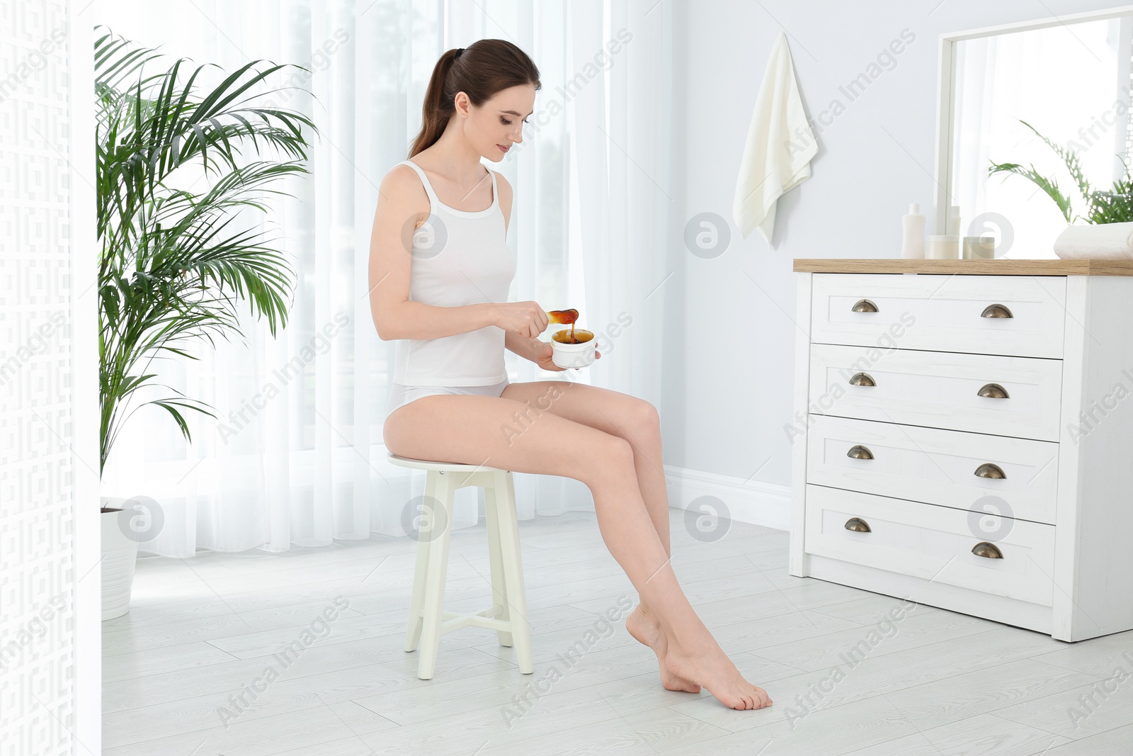 Photo of Young woman with hot wax at home. Epilation procedure
