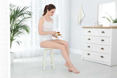 Young woman with hot wax at home. Epilation procedure